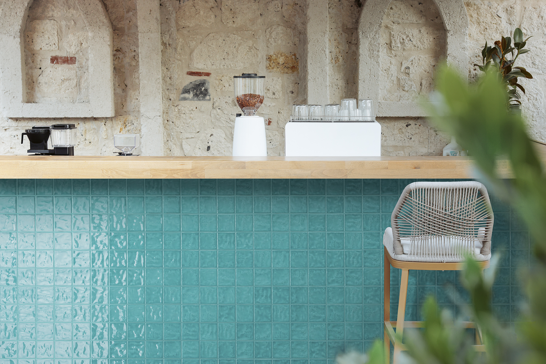Modern and luxury cafe design with wooden top black counter, digital cash register, stool in sunlight from reeded glass folding door
