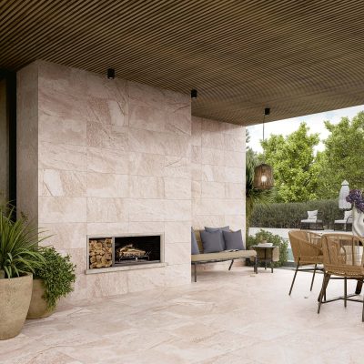 Pátio com pavimento e revestimento cerâmico que imita pedra quartzito, com realismo e veios marcados, série Pukka White da Recer.