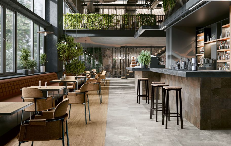 Restaurante moderno com chão cerâmico Recer: efeito madeira Opal Honey e cimento Metalcrete Warm Silver e Corten