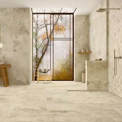 Cerâmica com efeito de pedra natural Rapolano Sand da Recer, numa casa de banho ampla e elegante.